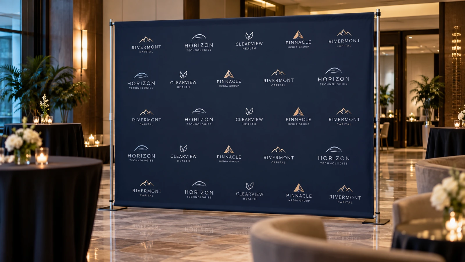 Navy sponsor-logo event backdrop installed on a freestanding display frame in a hotel function room
